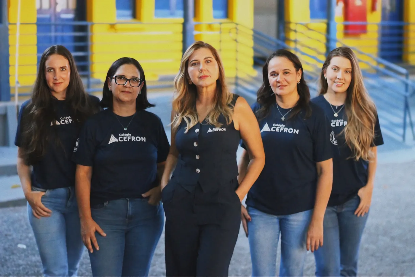 Equipe do Colégio Cefron em frente à fachada da escola